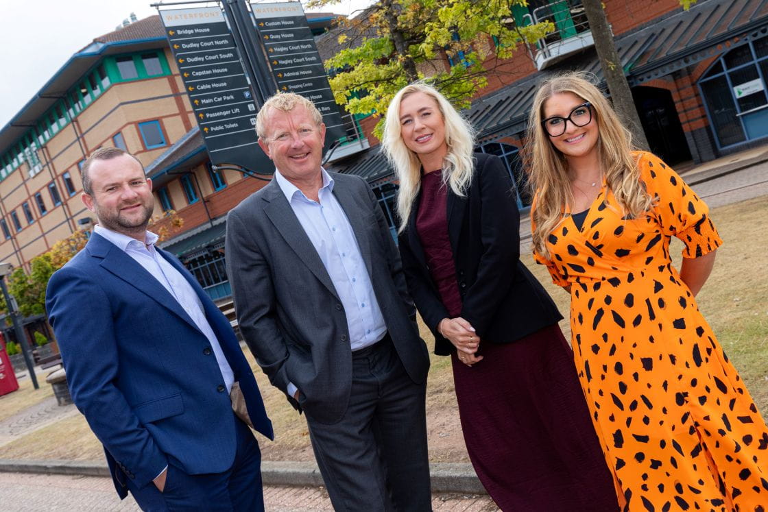Solicitor Emma Chater stands outside her new office with three colleagues. Two are men in suits and there is also a second woman pictured.