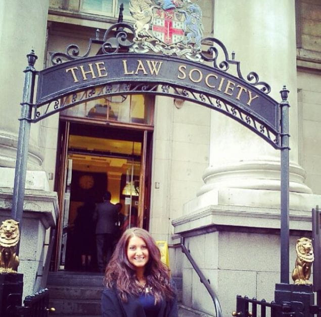 Solicitor Emma Chater stands in front of the Law Society whilst wearing ceremonial gowns at her admissions ceremony 