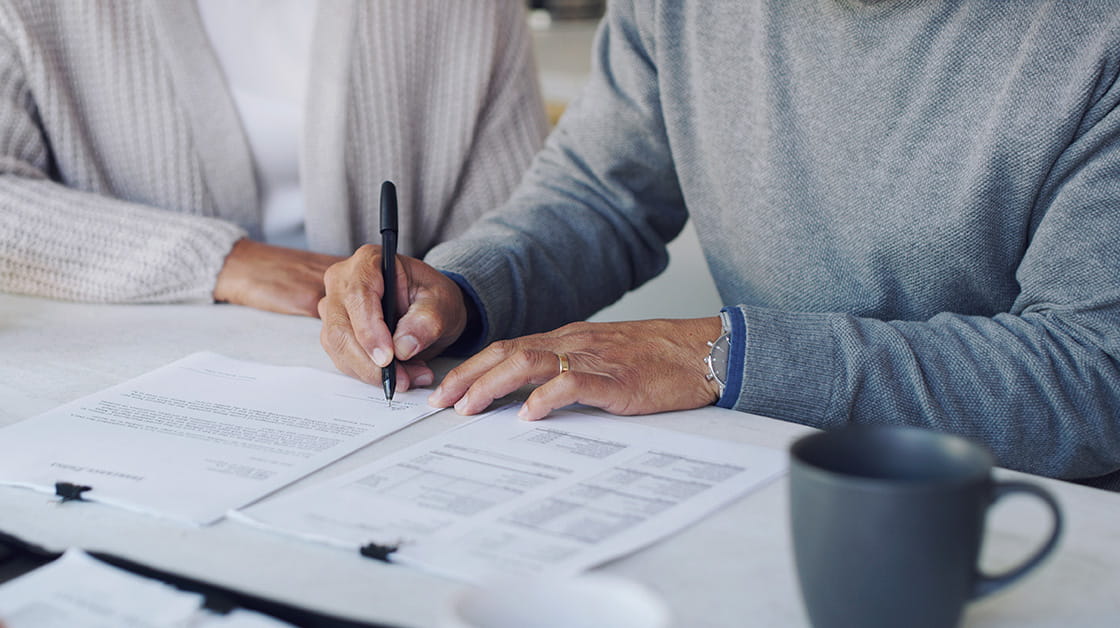 An older couple signs a last will and testament