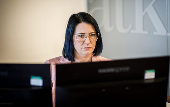 A solicitor sits at a computer.