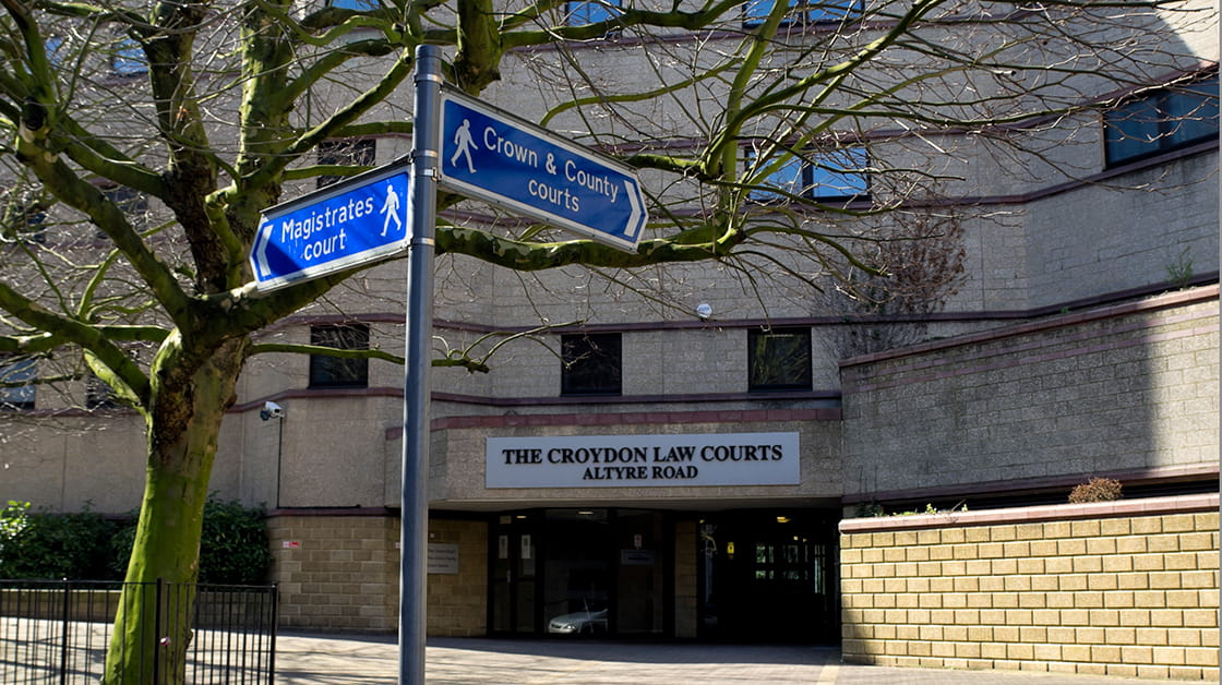 Signs pointing to Magistrates' Court, Crown and County Courts in front of  Croydon Law Courts buildings on sunny winter day  (Croydon, England - March 25, 2012)