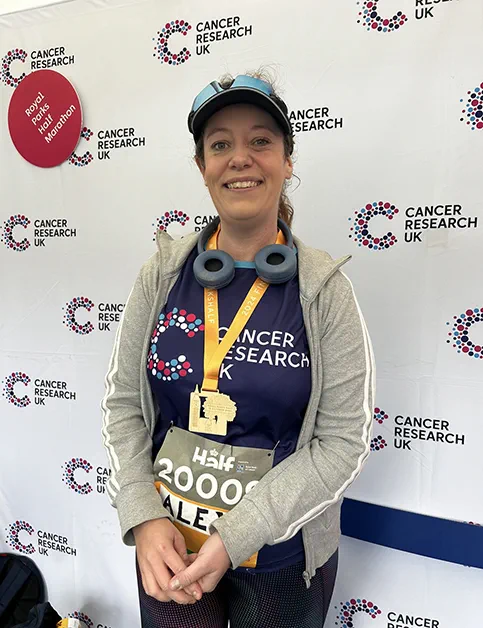 Solicitor Alexandra Wilson smiles, wearing a medal after a half marathon