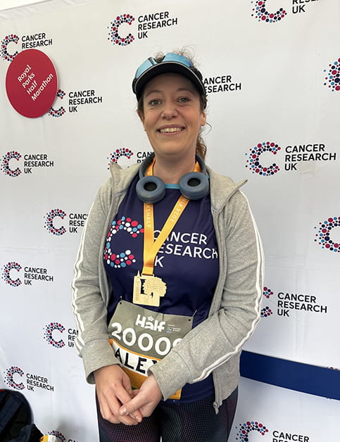 Solicitor Alexandra Wilson smiles, wearing a medal after a half marathon