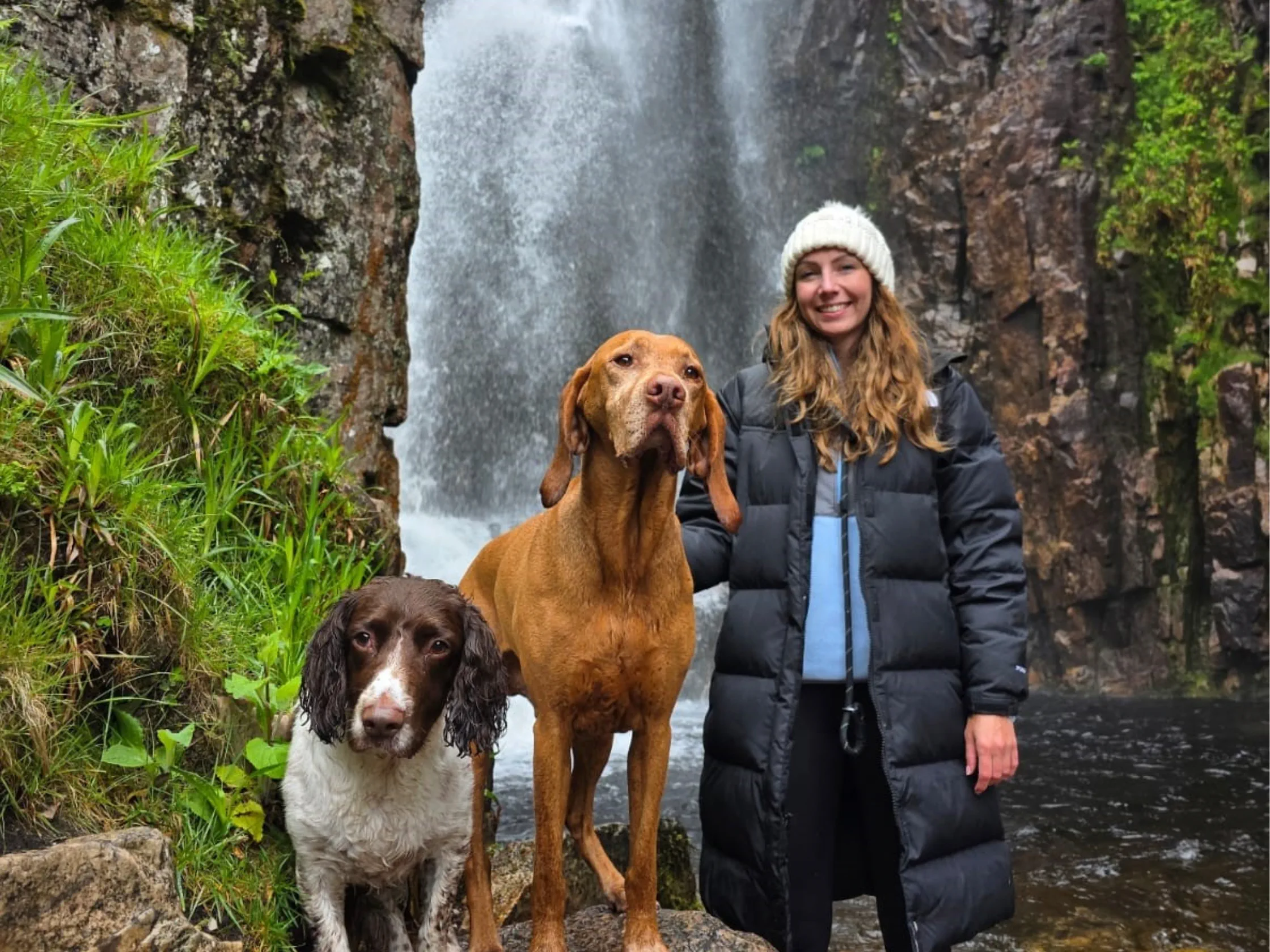 Amy Clowrey and two dogs by a waterfall/