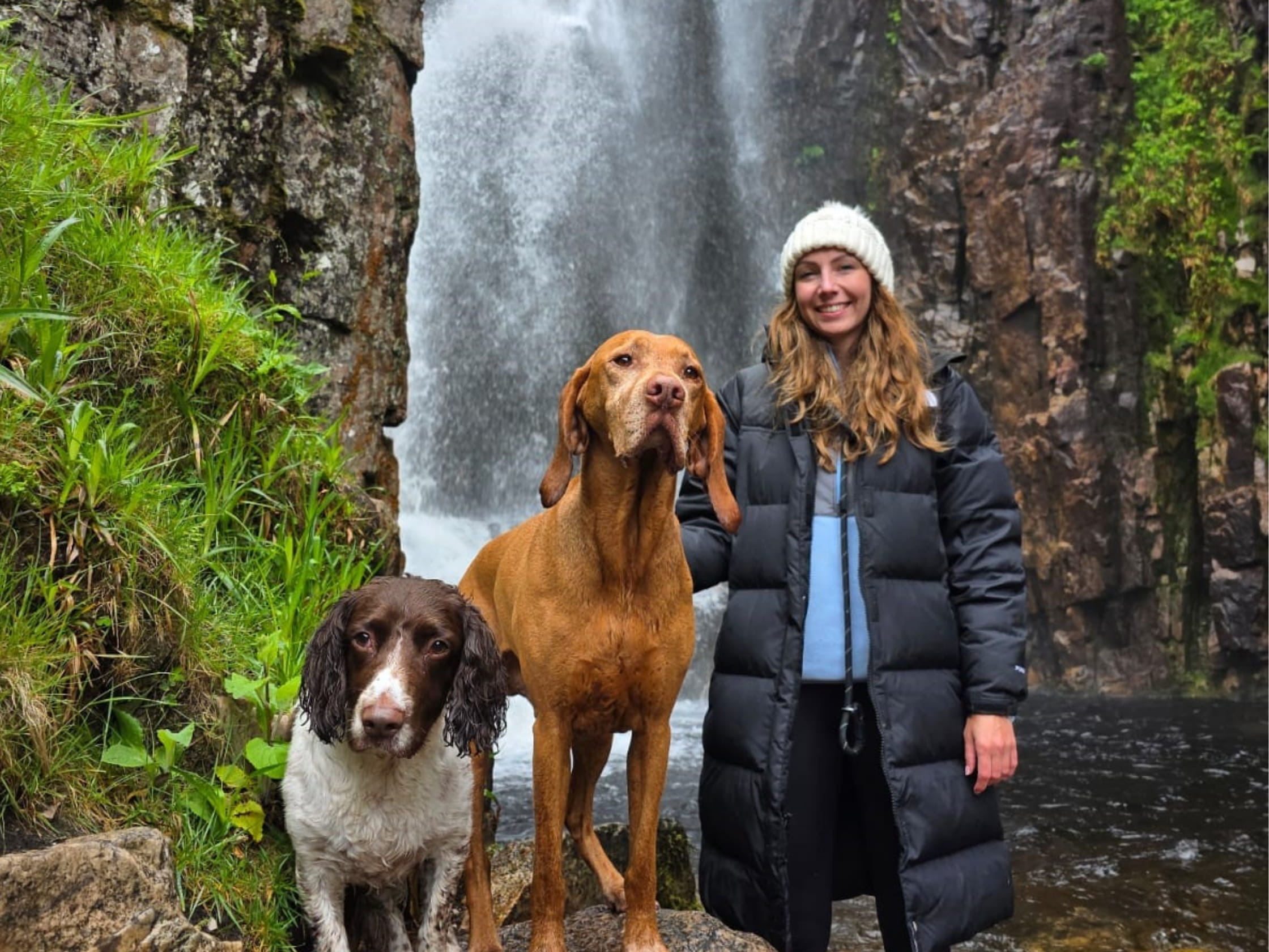 Amy Clowrey and two dogs by a waterfall/