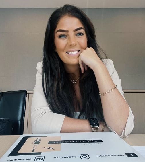 Solicitor Chrissie Wolfe smiles whilst sitting at a table