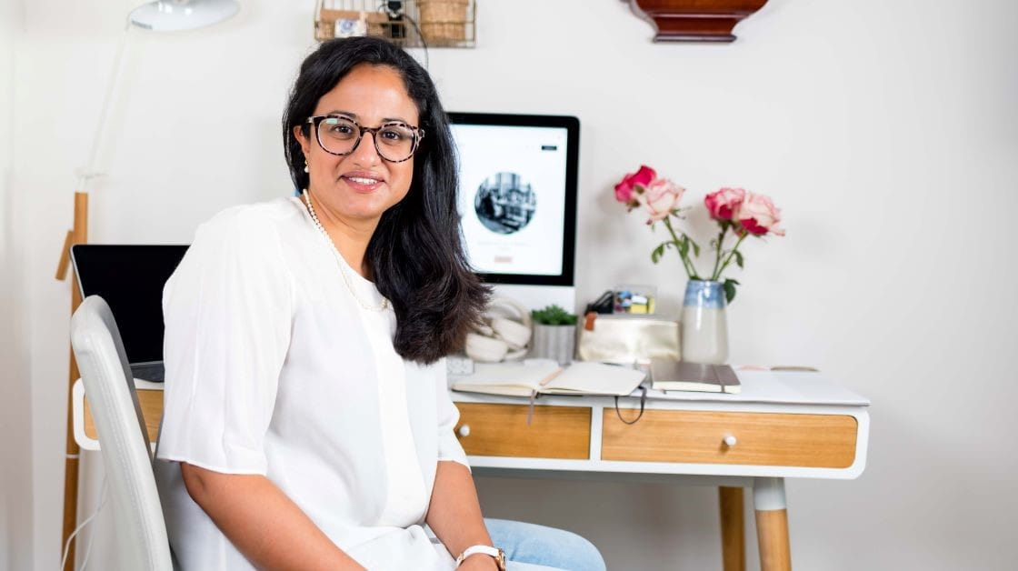 Solicitor Gulnaz Raja seated at her desk in front of her computer