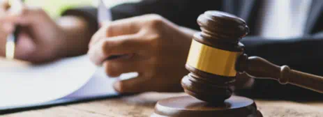 person at desk taking notes with a gavel